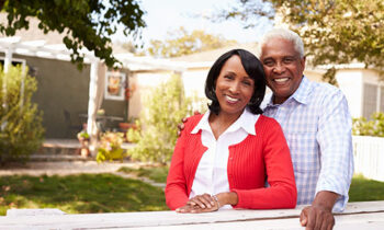 Image Text: 500x332_0002_Senior black couple look to camera outside their new house