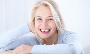 Image Text: Active beautiful middle-aged woman smiling friendly and looking in camera. Woman's face closeup. Realistic images -690x460